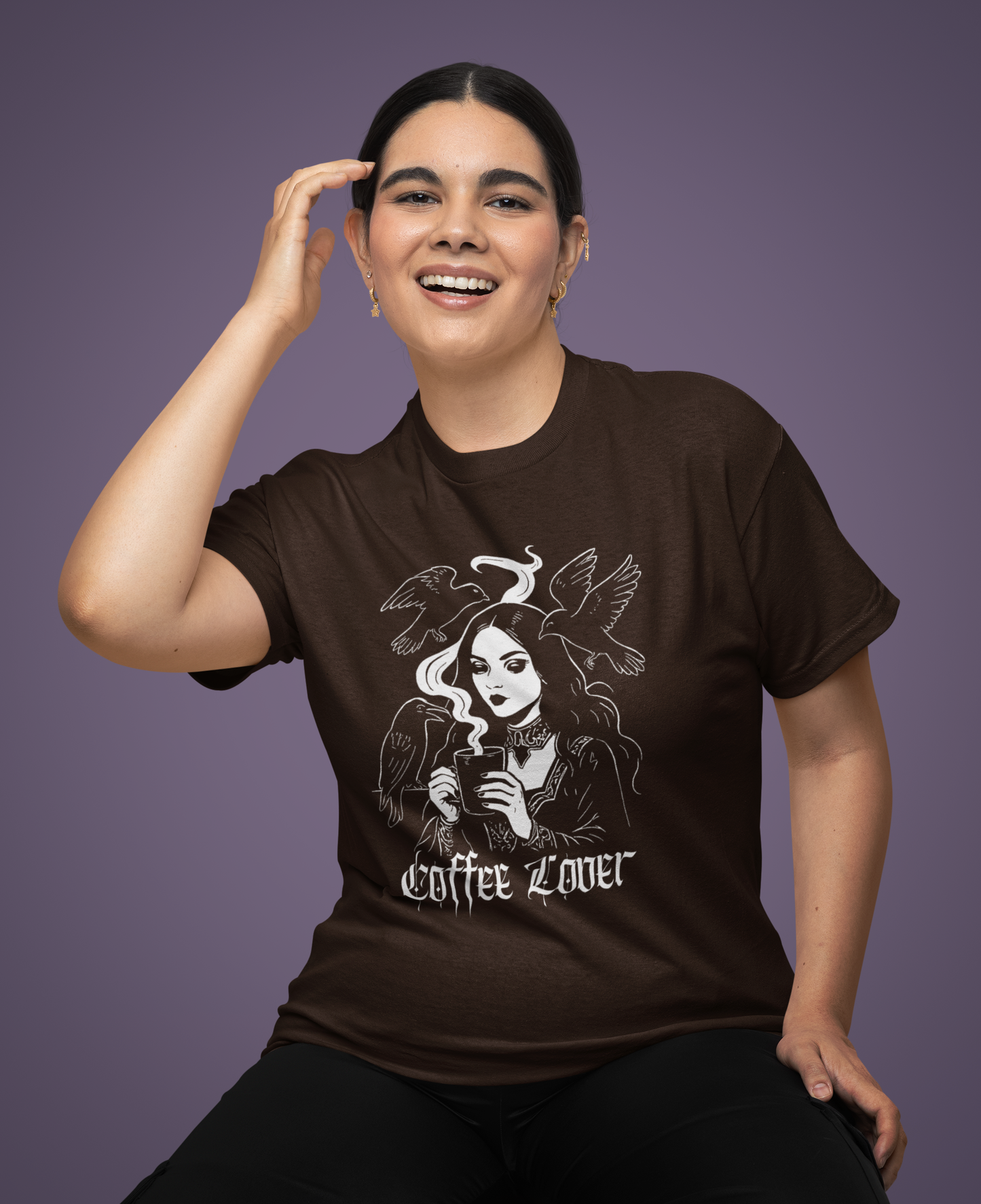 Woman wearing a brown t-shirt with a graphic design and text on a muted purple background