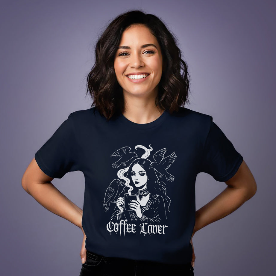 Woman wearing a gothic navy blue t-shirt with a graphic design of a woman with coffee cup, surrounded by birds and text 'coffee lover'