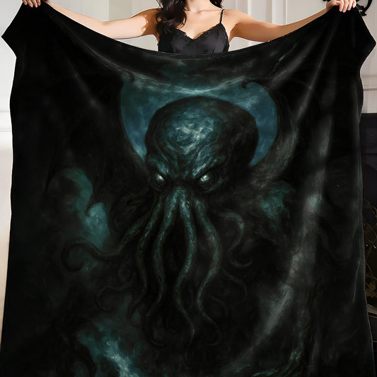 Person holding a black blanket with a dark painterly Cthulhu design