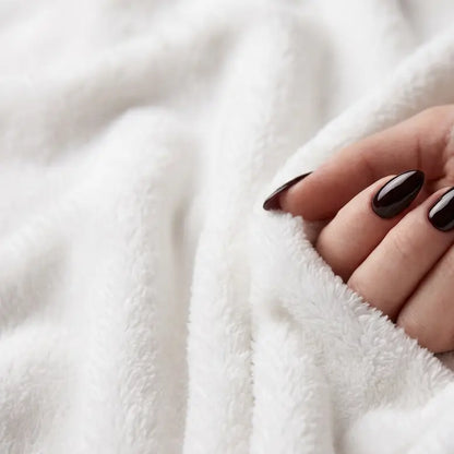 White plush texture up close with a manicured hand